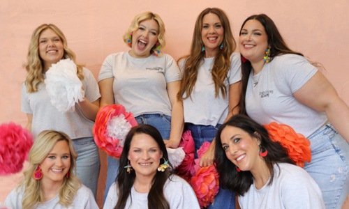 Close to the center of everything a group of women smiling at a camera