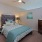 Spacious bedroom with bedside lamps and partial wall in apartment at Main + Stone